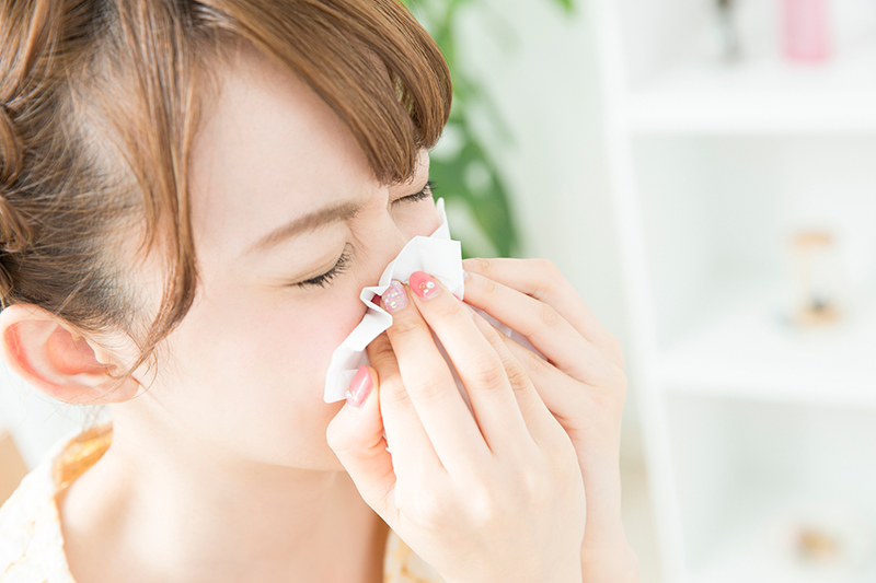 鼻をかんでいる女性